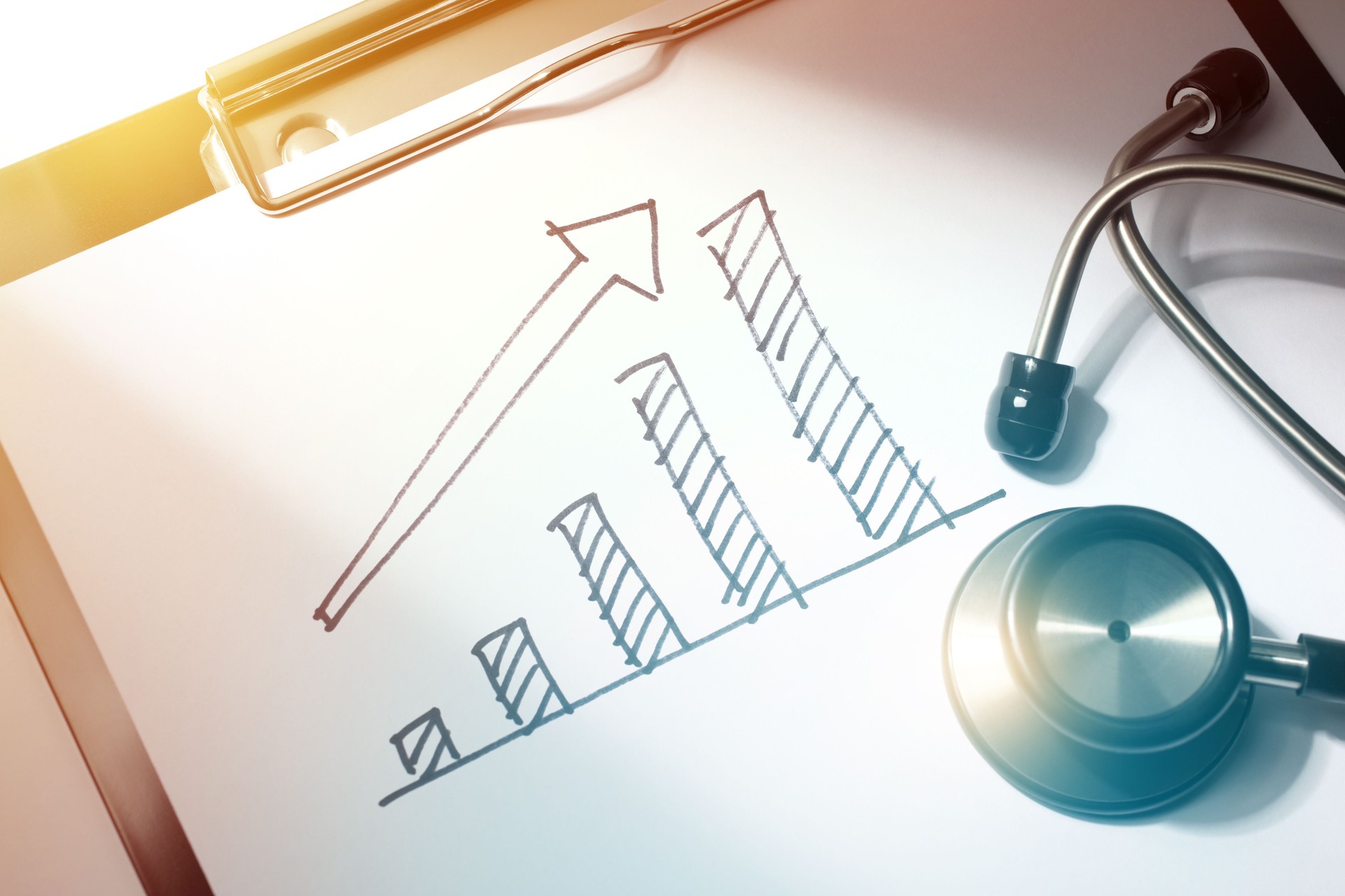 Medical Price Close-up of Financial Chart Drawing and Stethoscope on Doctors Report Clipboard